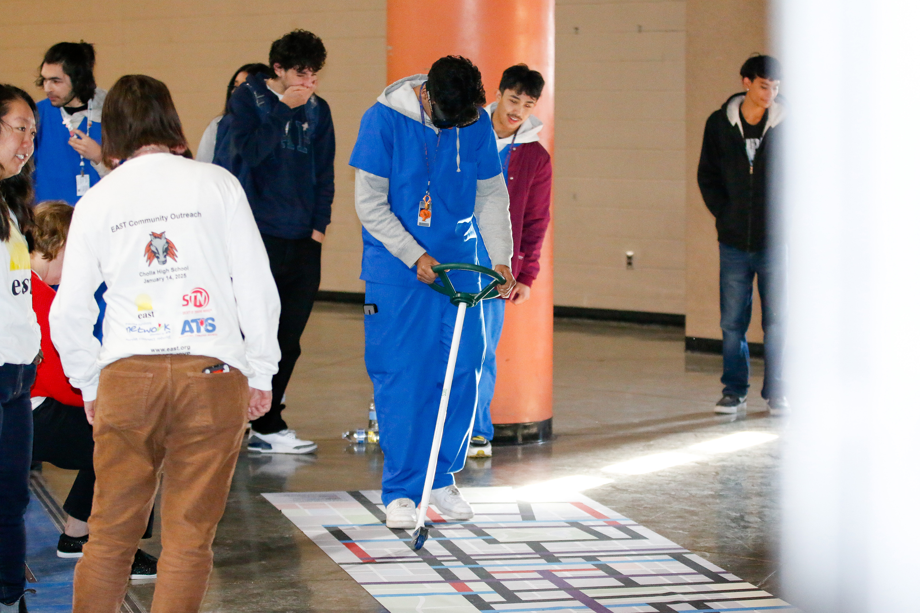 A student attempts to steer around a simulated street while wearing drunk goggles