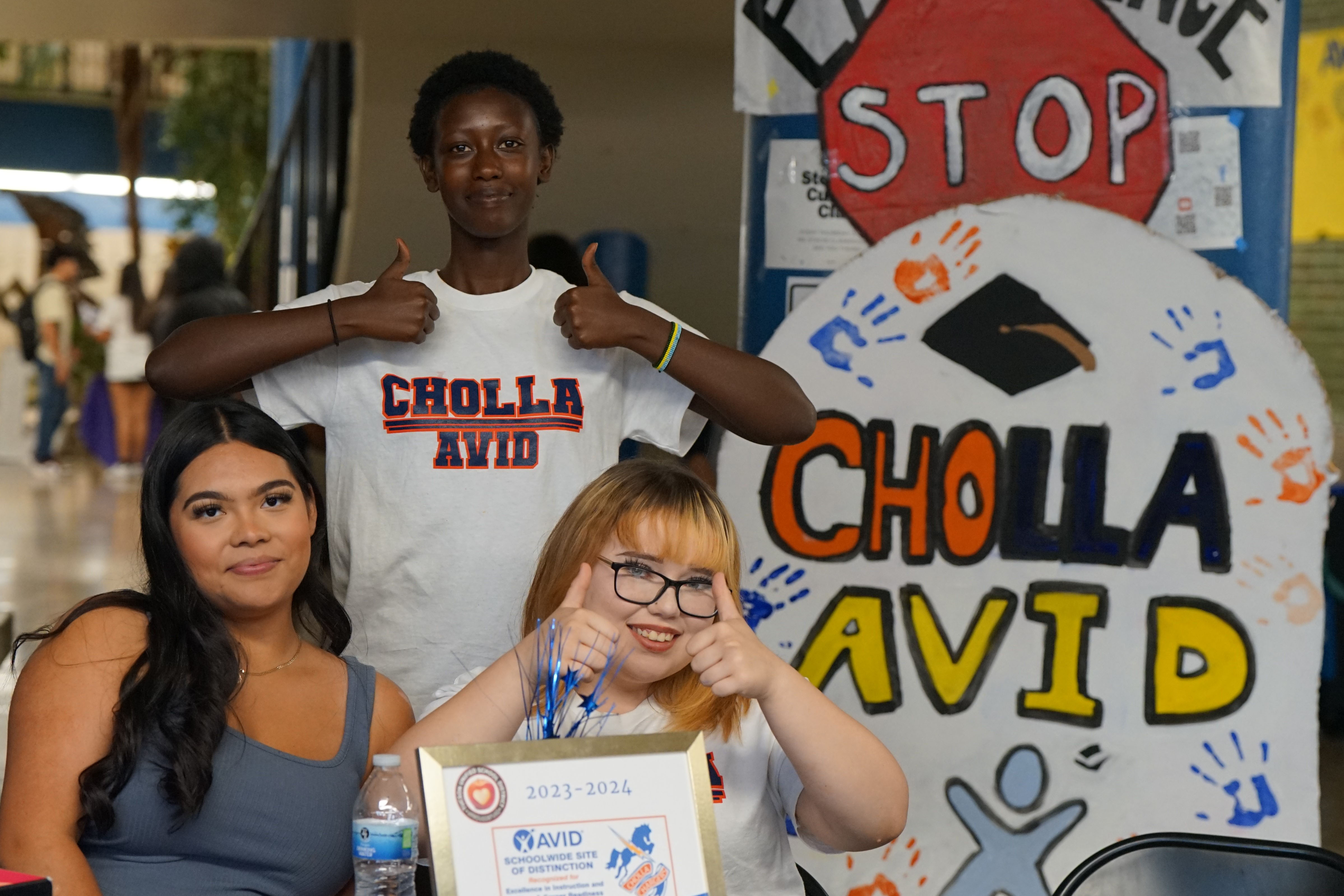 Three students at the Cholla AVID table give a thumbs up