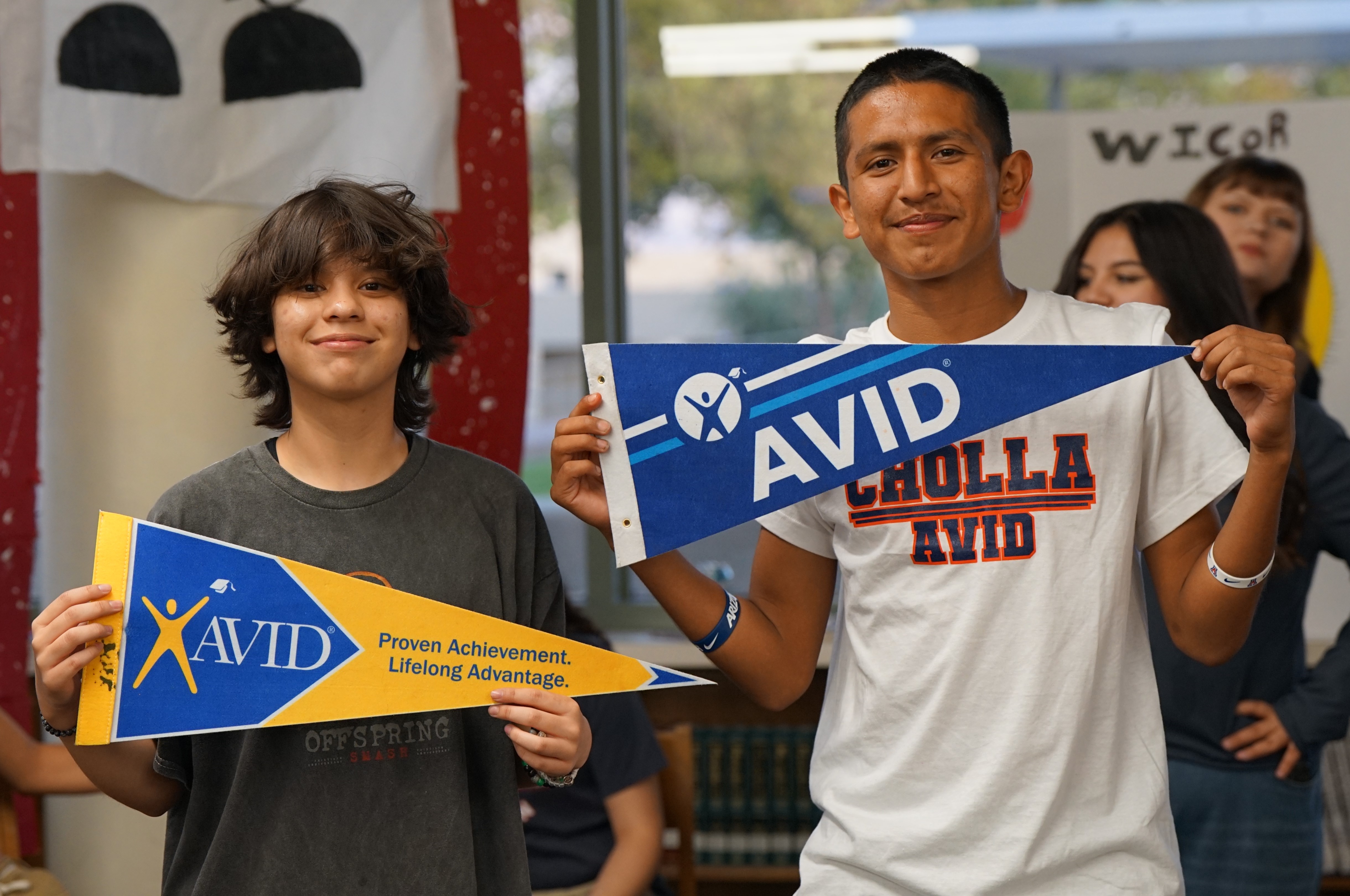 Two boys hold up AVID pennants