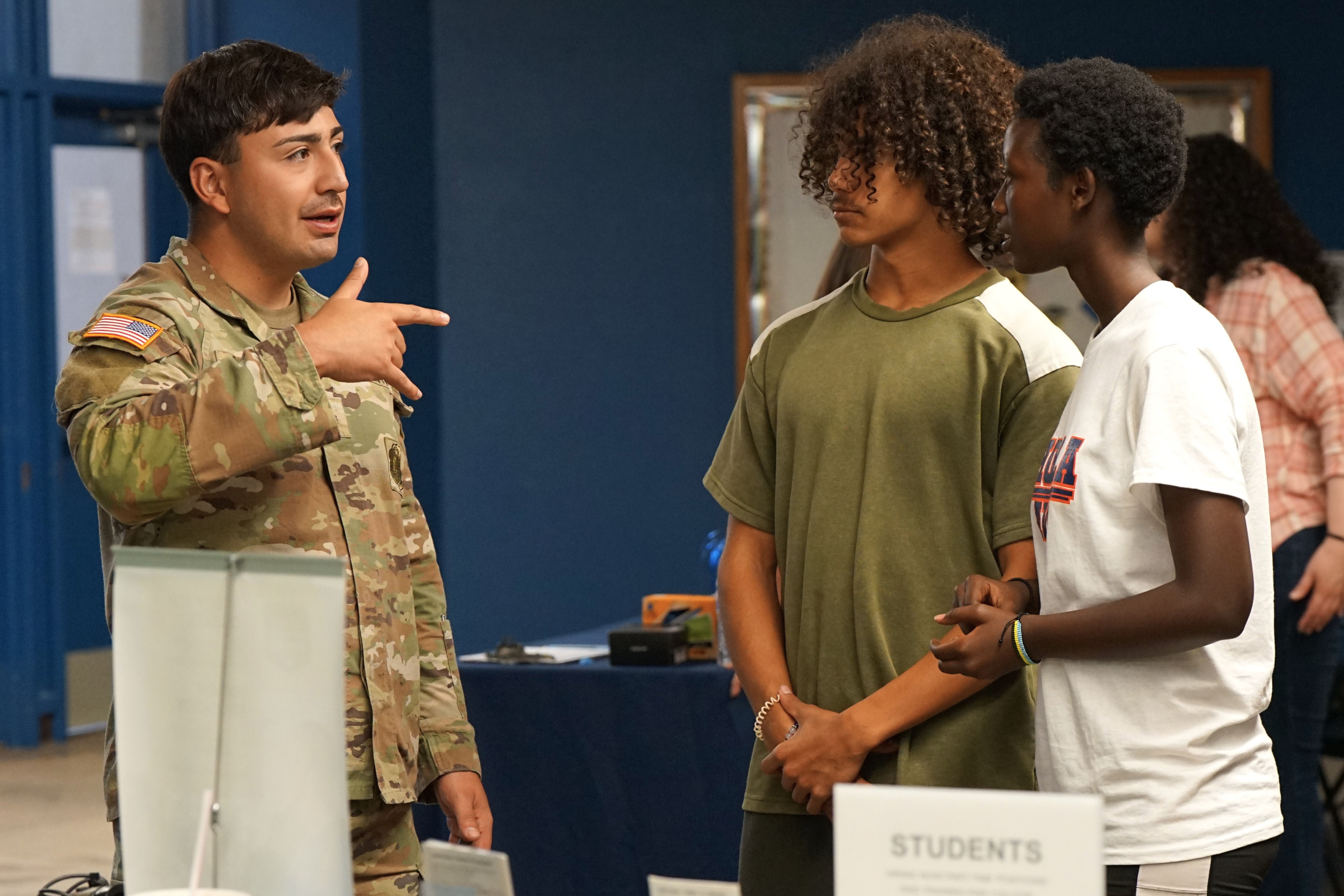 An Army recruiter talks to two students