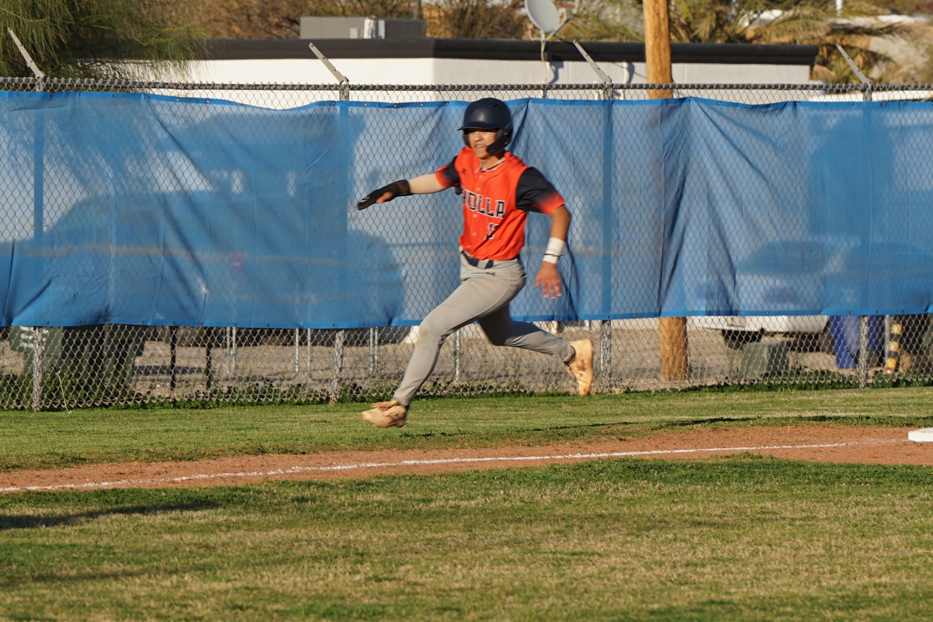 A baseball player runs around the field