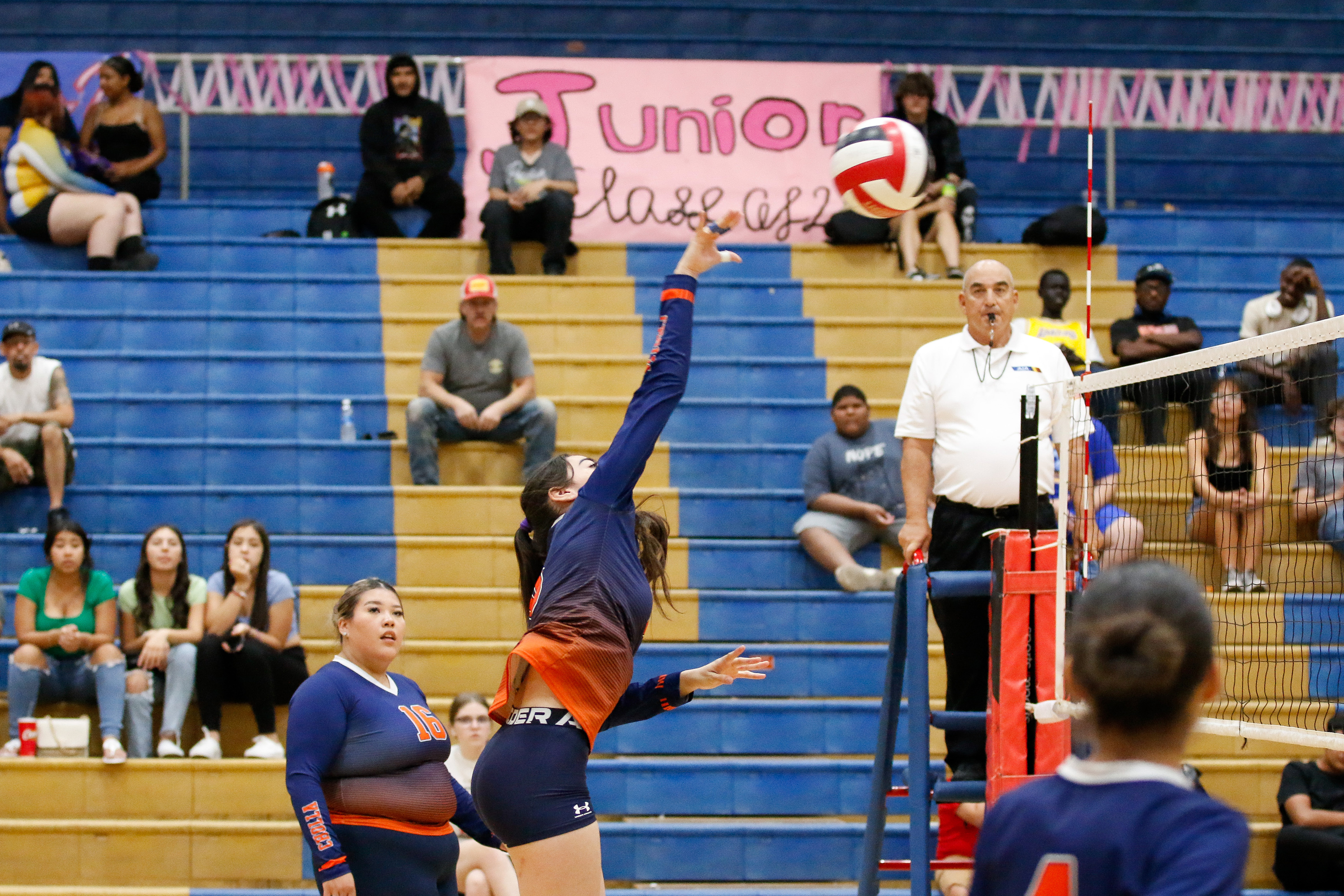 A Cholla volleyball player spikes the ball over the net