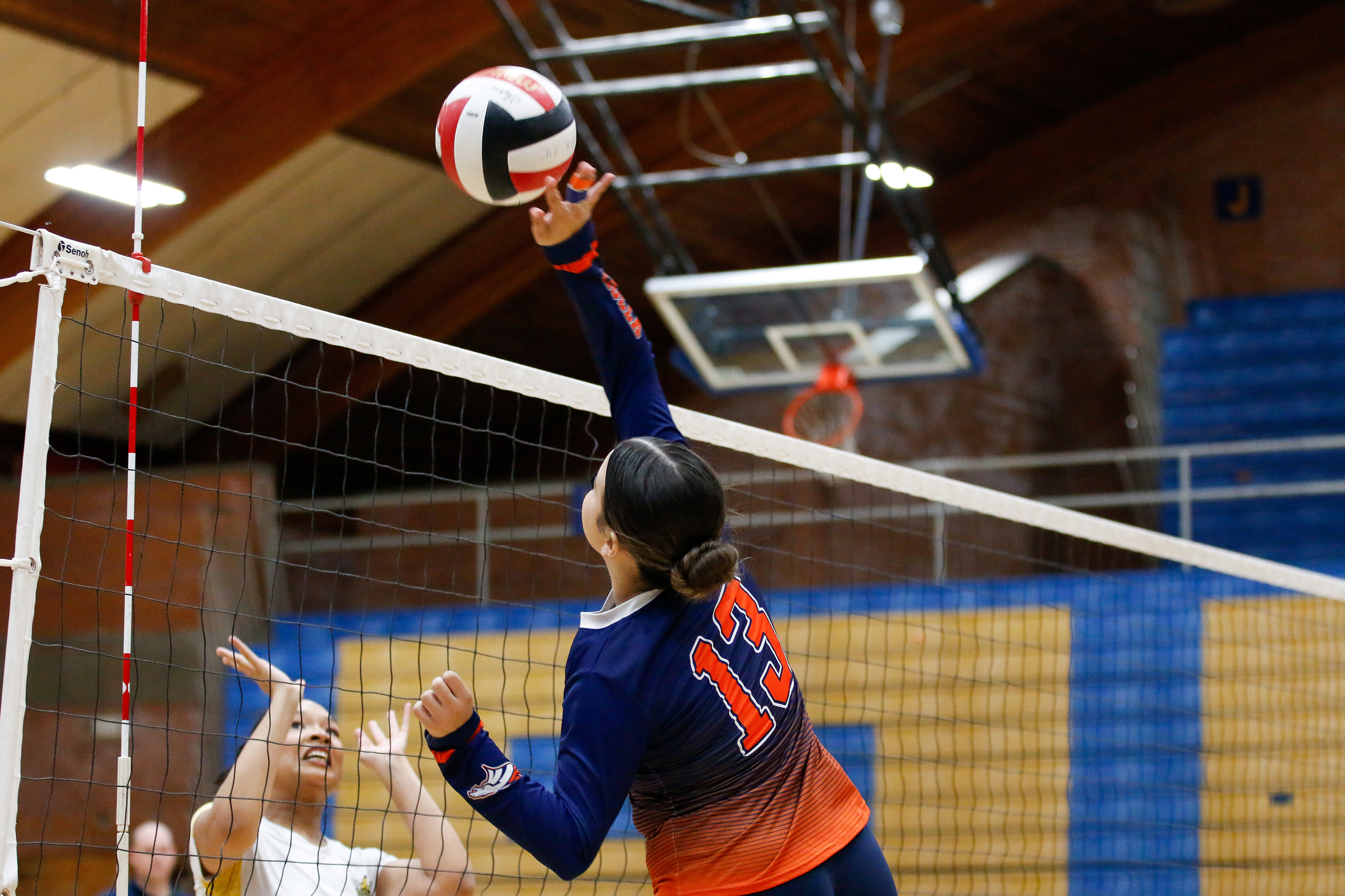 A Cholla volleyball player hits the ball over the net