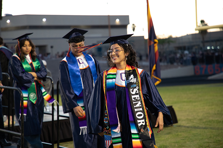 A graduate tosses her tassel as she walks off stage