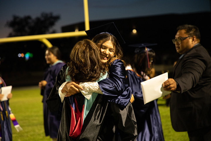 A graduate hugs her mom
