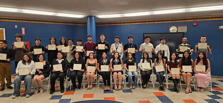 A group of students hold up certificates