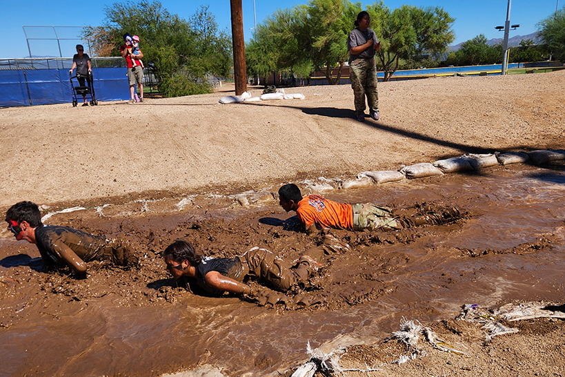 JROTC students crawl through a mud put
