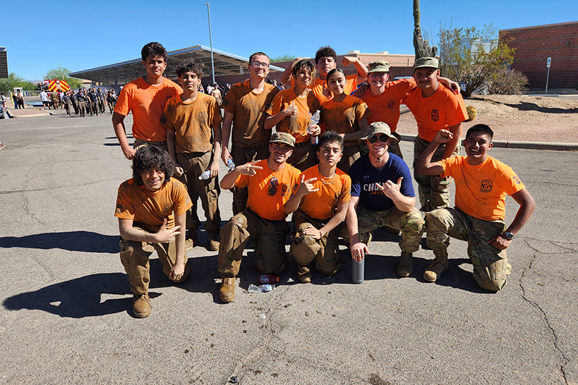 JROTC students in their orange shirts pose for a group photo