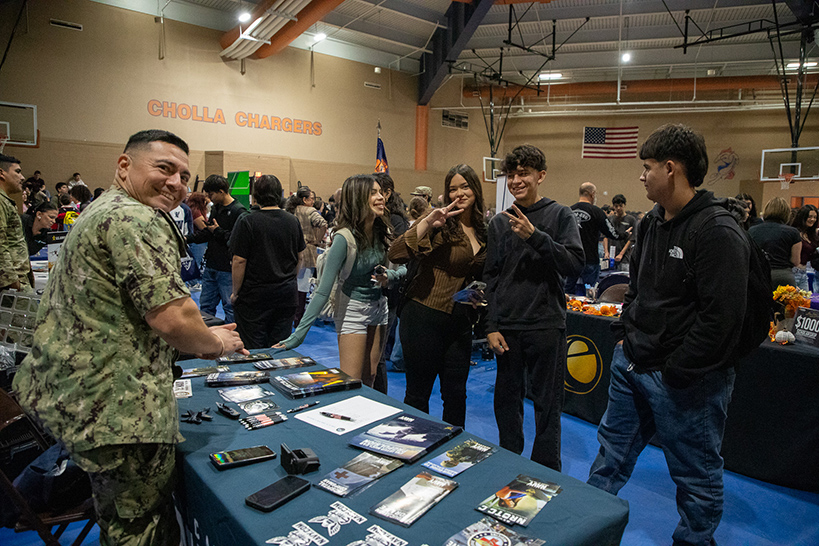 A man in military fatigues turns to smile from his table