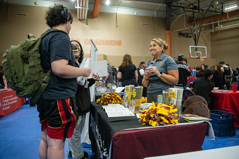 Students talk to a woman behind a table