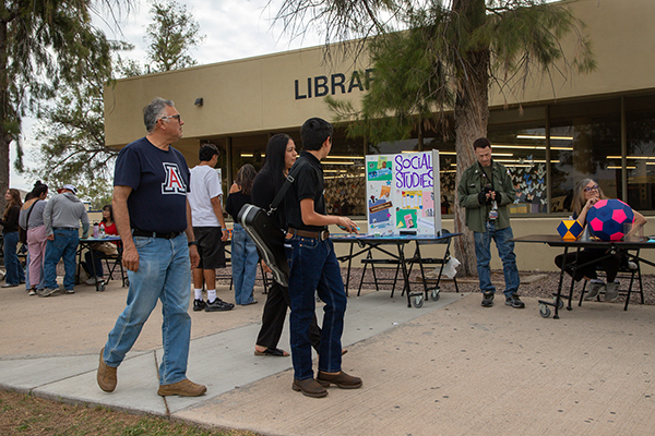 Families walk by tables at the resource fair outside