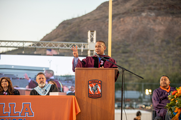 Dr. Trujillo holds up three fingers during his graduation speech