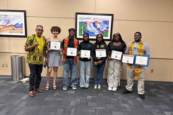 A group of high school students pose with their award certificates