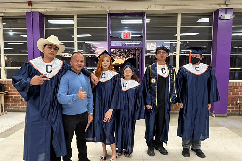 A principal and five of his students in their caps and gowns