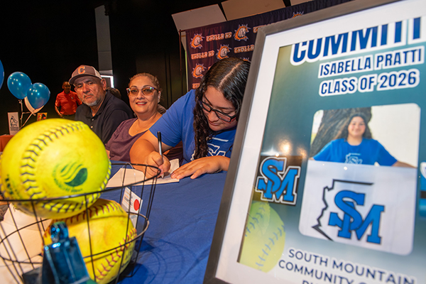 A teen girl signs her college letter of intent