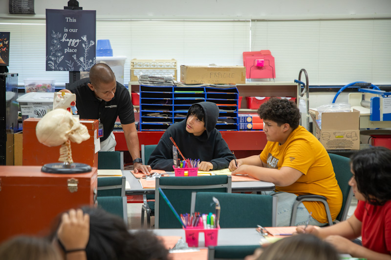 Dr. Trujillo looks at students' work in the science lab